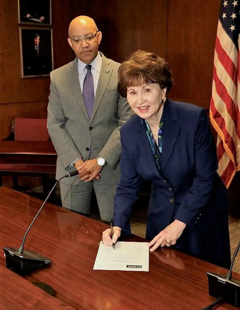 Hope Williams in office with Thomas Siith signing document